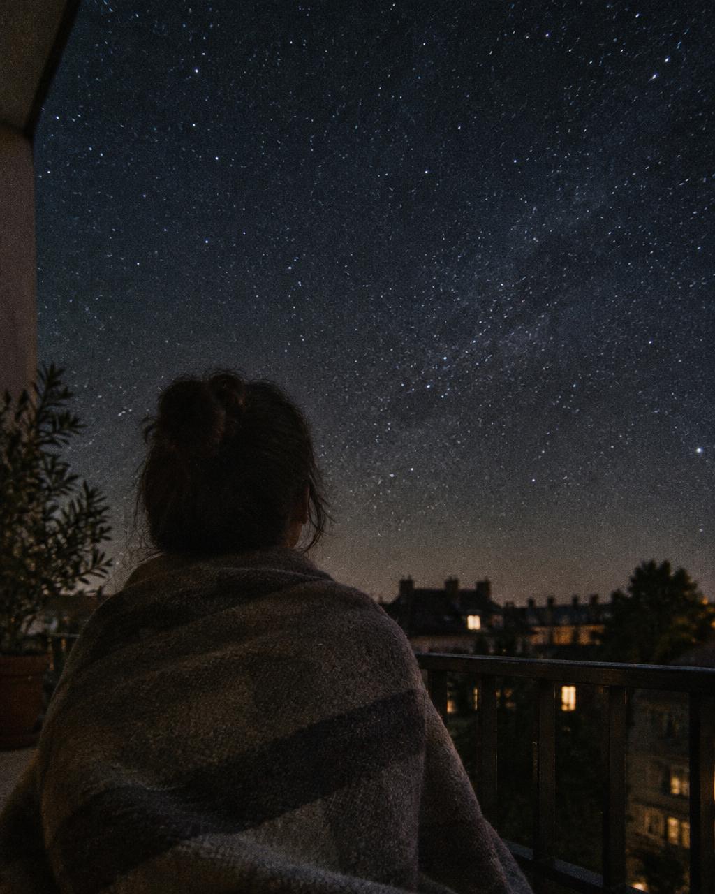 Un thème astral imprimé posé sur une table de cuisine le soir, près d'une tasse