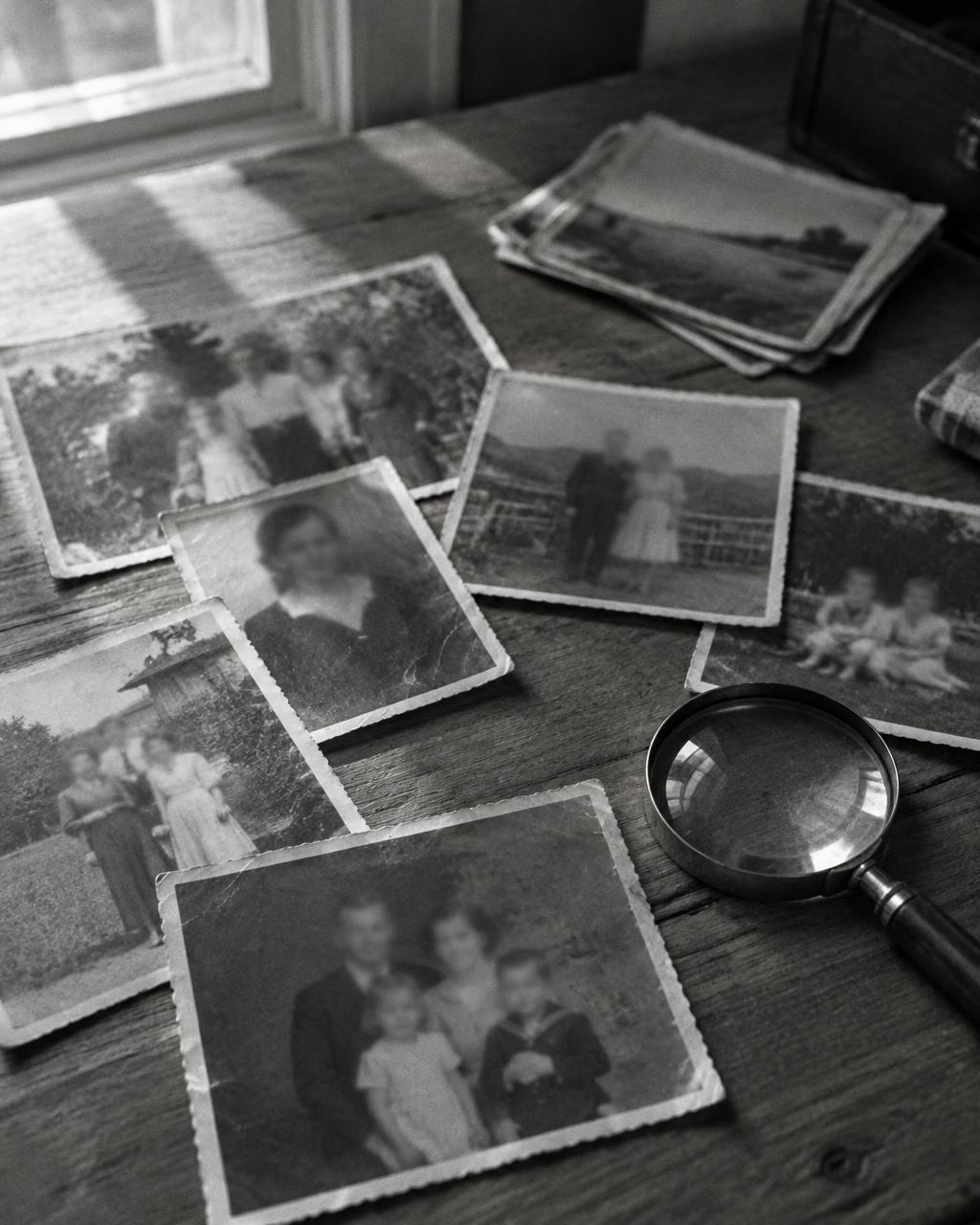 Des photos de famille anciennes étalées sur une table en bois